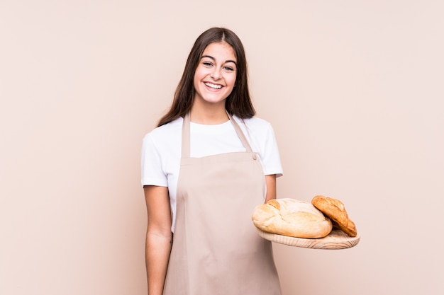 De jonge Kaukasische bakkersvrouw isoleerde gelukkig, glimlachend en vrolijk.