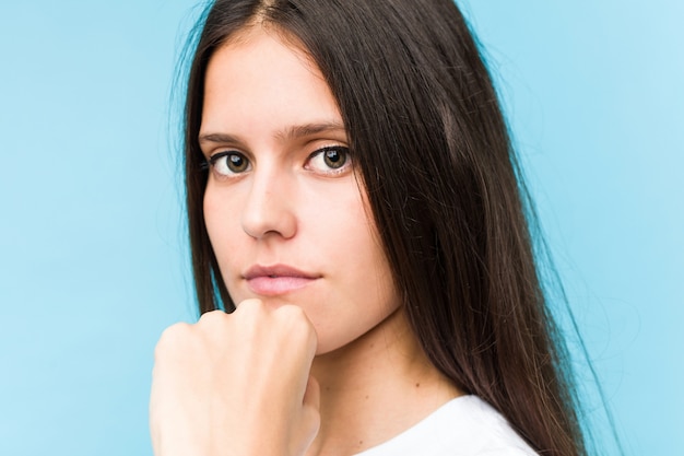 De jonge Kaukasische die close-up van het meisjesgezicht in blauw wordt geïsoleerd
