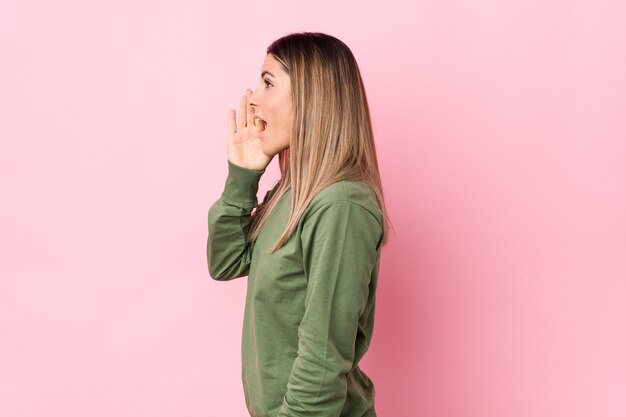 De jonge Kaukasische vrouw isoleerde het schreeuwen en het houden van palm dichtbij geopende mond.