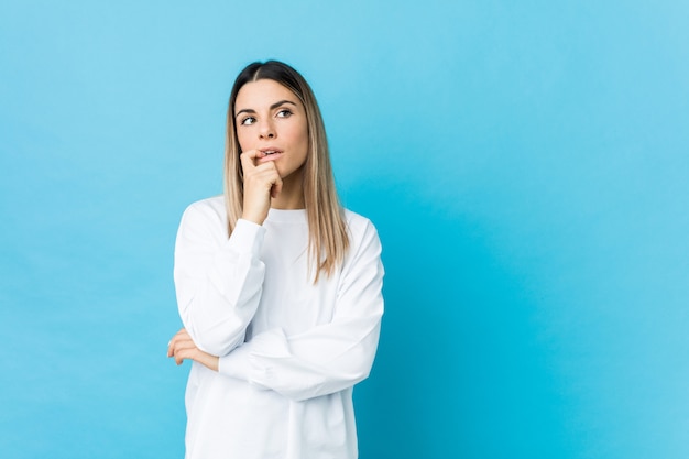 De jonge Kaukasische vrouw isoleerde ontspannen denkend aan iets bekijkend een exemplaarruimte.