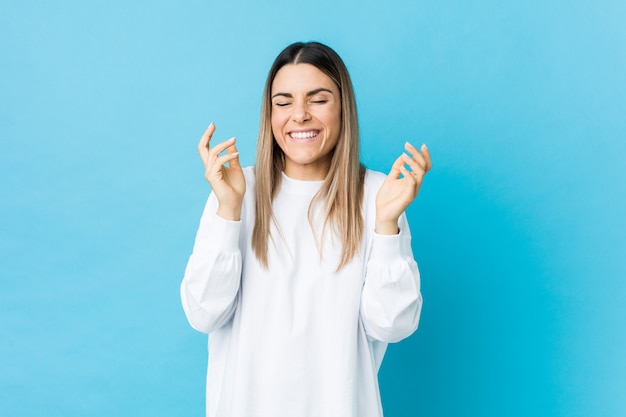 De jonge Kaukasische vrouw isoleerde vreugdevol veel lachen. Geluk concept.