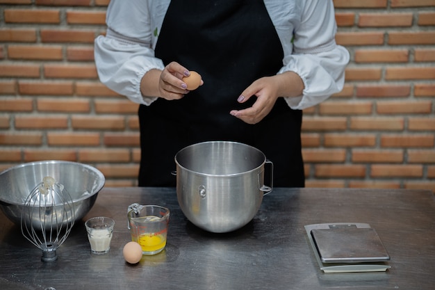 De jonge kokende cake van de vrouwenchef-kok in keuken