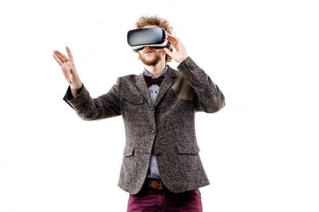 De jonge krullende-haired zakenman die bruin kostuum draagt gebruikt VR-hoofden