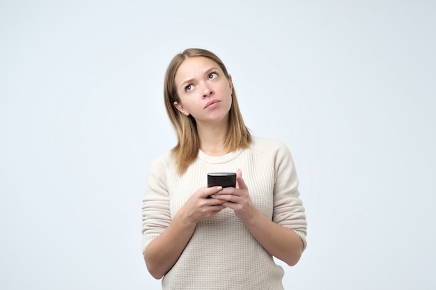 De jonge leuke aantrekkelijke vrouw schrijft wat tekst of gebruikt een slimme telefoon