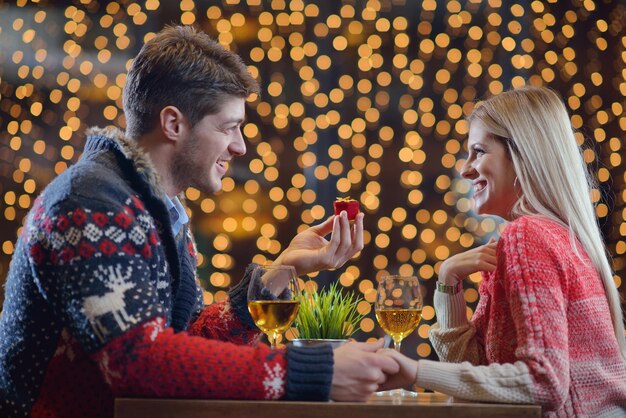 De jonge man geeft een trouwring cadeau aan meisje in restaurant