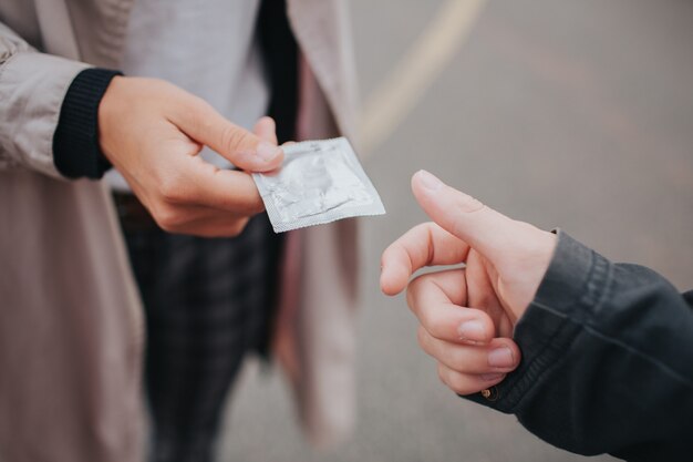 De jonge man geeft het condoom door aan de vrouw