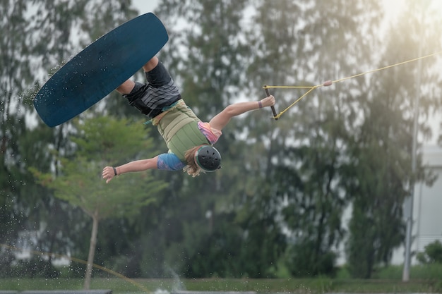 De jonge man springt tijdens het wakeboarden. extreme sporten voor de lol.