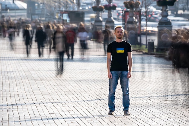 De jonge man staat midden in een drukke straat