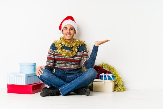 De jonge mens op Kerstmisdag met duimen UPS, juicht over iets, steun en eerbiedconcept toe.