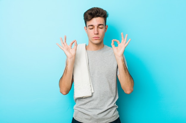 De jonge mens van de geschiktheidstiener ontspant na harde werkdag, voert zij yoga uit.