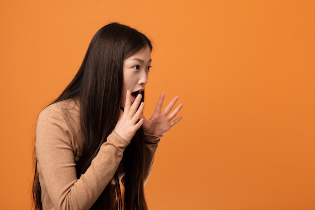 De jonge mooie Chinese vrouw schreeuwt luid, houdt ogen geopend en geeft de handen.