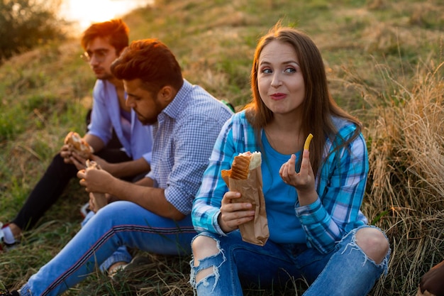 De jonge multi-etnische studenten die fastfood eten op de campus