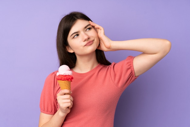 De jonge oekraïense tienervrouw die een cornetroomijs houden die twijfels hebben en met verwart gezichtsuitdrukking