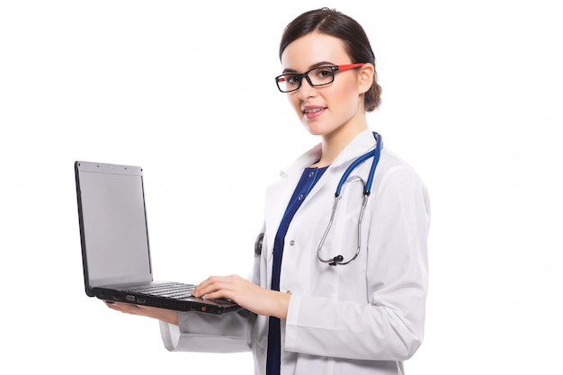 De jonge vrouw arts met laptop van de stethoscoopholding in haar dient witte eenvormig in