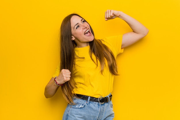 De jonge vrouw die van de gemberroodharige vuist na een overwinning, winnaarconcept opheffen.