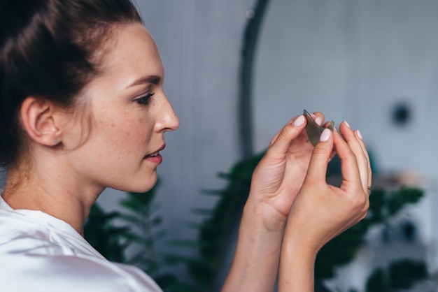 De jonge vrouw houdt een pleister in haar hand voordat ze deze op haar huid aanbrengt.