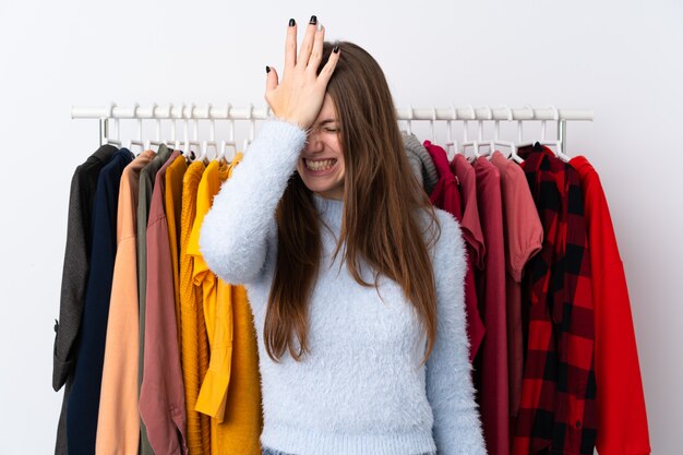 De jonge vrouw in een kledingsopslag die twijfels hebben met verwart gezichtsuitdrukking