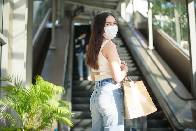 De jonge vrouw met gezichtsmasker bevindt zich openlucht