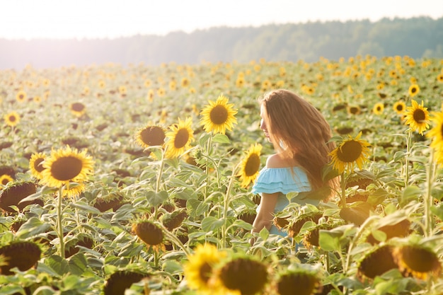 De jonge vrouw op zonnebloemgebied heeft pret