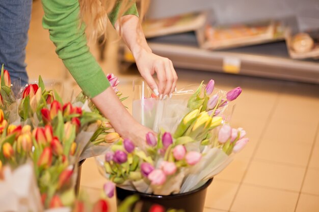 De jonge vrouw plukt tulpen in de opslag