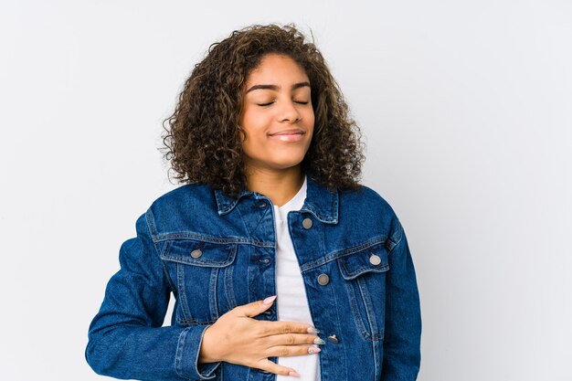 De jonge vrouw raakt buik, glimlacht zacht, het eten en tevredenheidsconcept.