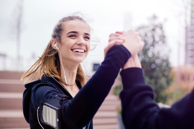 Foto de jonge vrouw schudt de arm van haar personal trainer