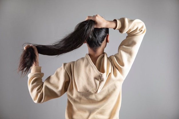 De jonge vrouw staart het haar