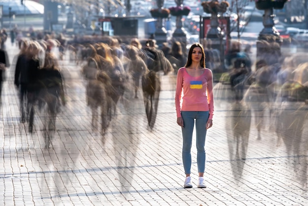 Foto de jonge vrouw staat midden in een drukke straat