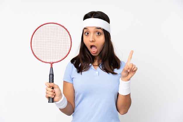 De jonge vrouw van de badmintonspeler over geïsoleerde witte muur die een idee denken die de vinger benadrukt