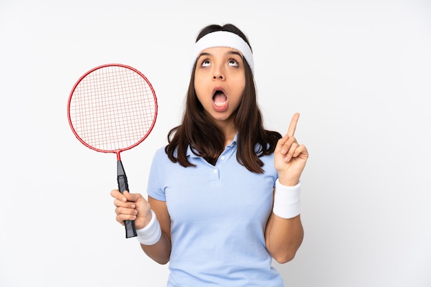 De jonge vrouw van de badmintonspeler over geïsoleerde witte verraste en benadrukte muur