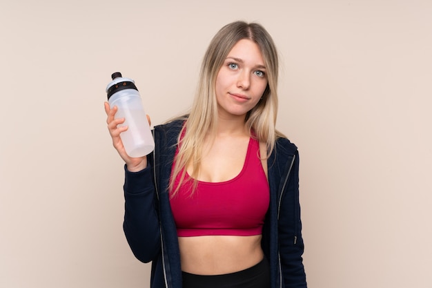 De jonge vrouw van het sportblonde met de fles van het sportenwater