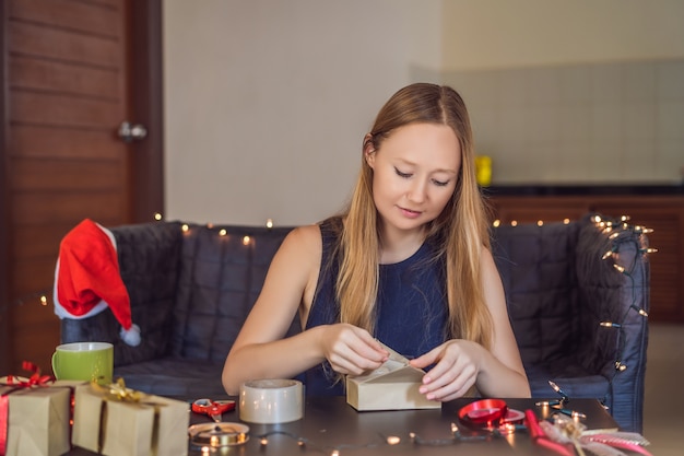 De jonge vrouw verpakt cadeautjes