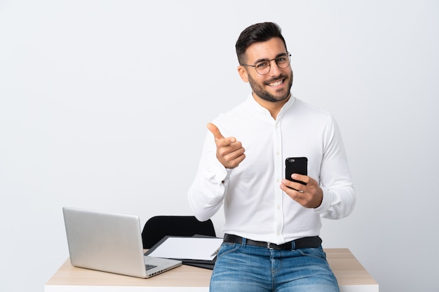 De jonge zakenman die een mobiele telefoon houden richt vinger op u