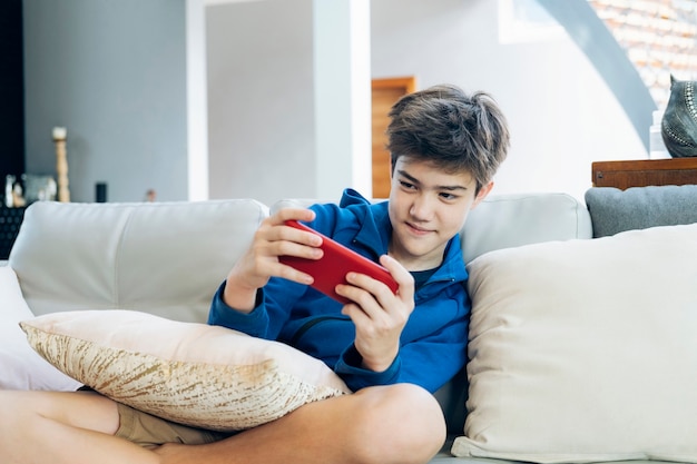 De jongen die thuis online spel op smartphone speelt.