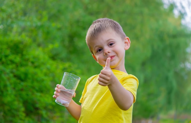 De jongen drinkt water uit een glas Zuiver water Zomer