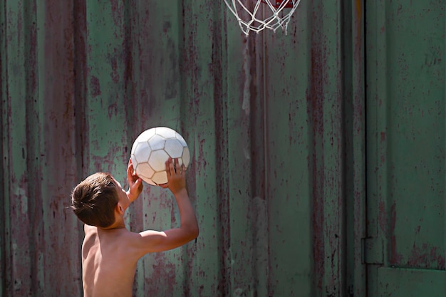 De jongen gooit de bal in de ring