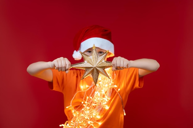 De jongen houdt in zijn handen en toont een close-up van een kerstboomster