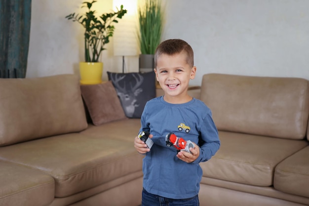 de jongen kijkt naar de camera en houdt een speeltje in zijn handen