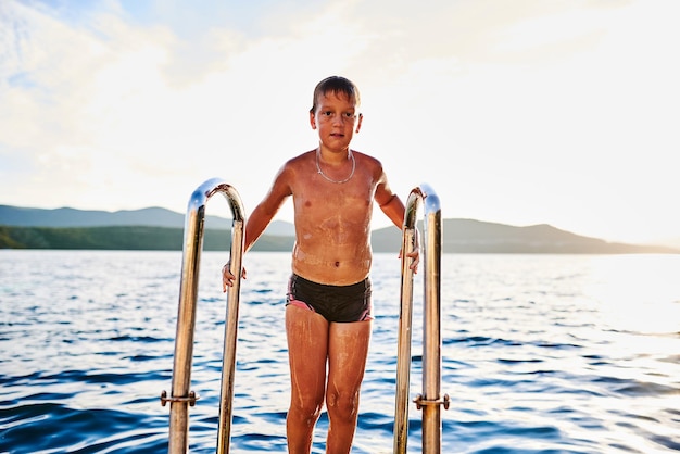 De jongen komt uit de zee na het baden. Foto van hoge kwaliteit