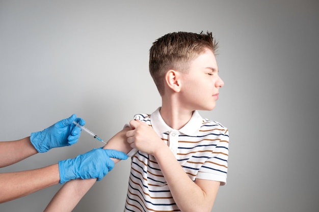 De jongen krijgt een injectie in zijn arm