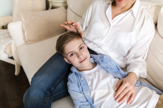 De jongen ligt op de schoot van de vrouw