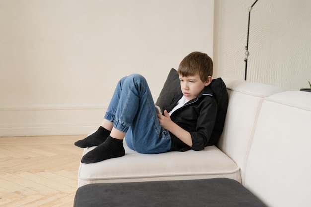 De jongen speelt met de telefoon, het probleem van technologie en moderne kinderen.