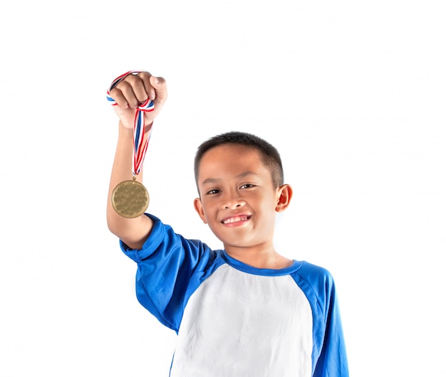 De jongen toont de gouden medaille, blij en trots.