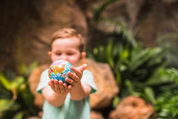 Foto de jongen van de de holdingsbol van de defocusedjongen in zijn hand