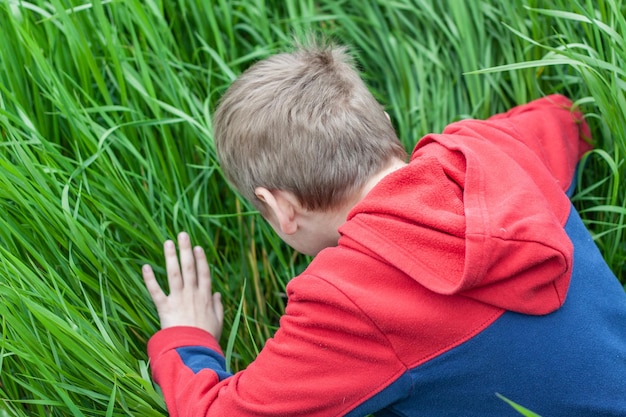 Foto de jongen verstopt zich in het gras