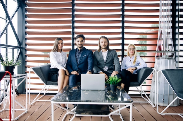 De jongerengroep in modern kantoor heeft teamvergadering en brainstorming terwijl het werken aan laptop