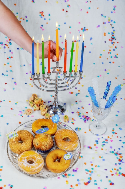 De kaarsen van de vrouwelijke handverlichting in menorah dienden voor Chanoeka