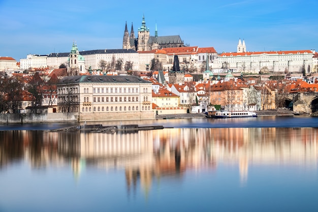 De Karelsbrug, de Sint-Vituskathedraal en andere historische gebouwen in Praag weerspiegeld in de rivier