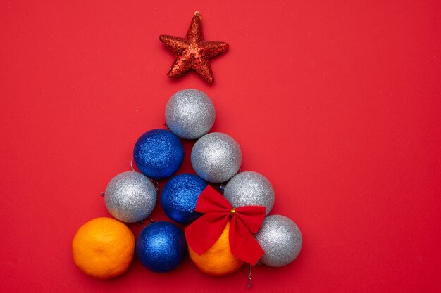 De kerstboom is gemaakt van mandarijnen en kerstballen. het concept van het nieuwe jaar.