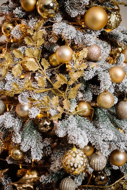 De kerstboom is versierd met gouden speelgoed voor het nieuwe jaar.